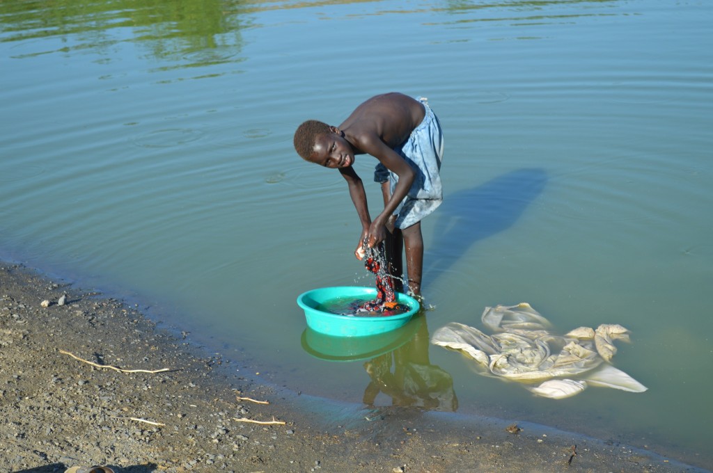 A child does laundry in a water catchment built by the Spanish Nariokotome Mission in northern Turkana. Most children in Turkana do not go to school and marry young, disqualifying them from training programs for high-level jobs.